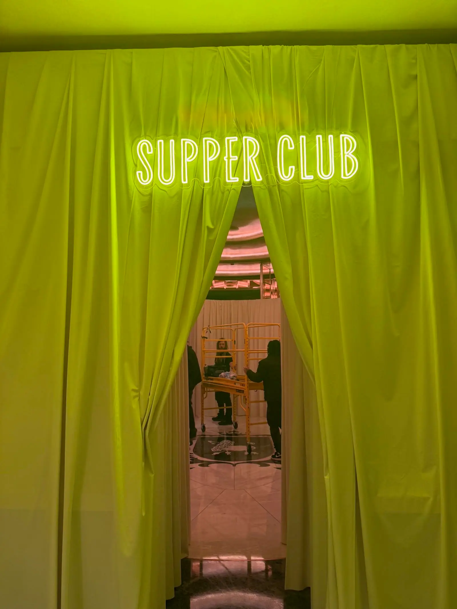 Supper Club neon sign with green-lit curtain entrance